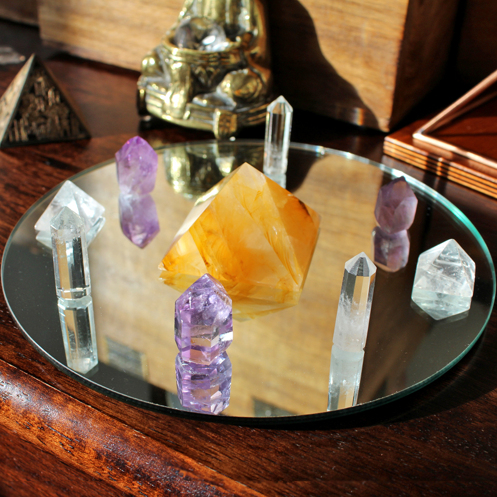 Crystal grid on a mirror with Golden Healer Quartz pyramid in the centre