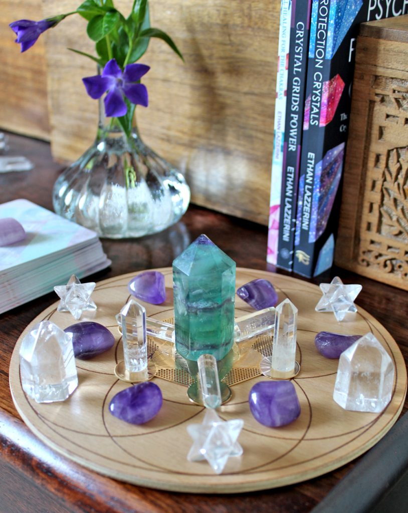 purple and green crystal grid with flowers andmy books